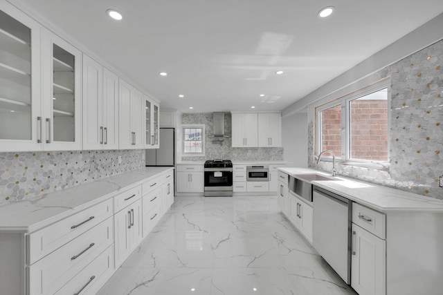 kitchen featuring tasteful backsplash, a sink, appliances with stainless steel finishes, recessed lighting, and wall chimney exhaust hood