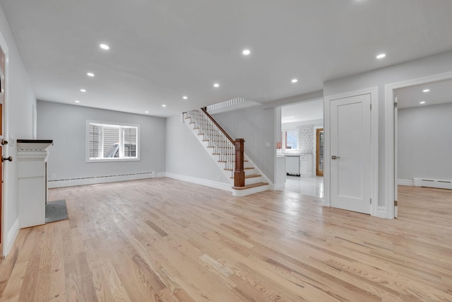 below grade area with light wood-style floors, baseboards, stairs, and a baseboard radiator