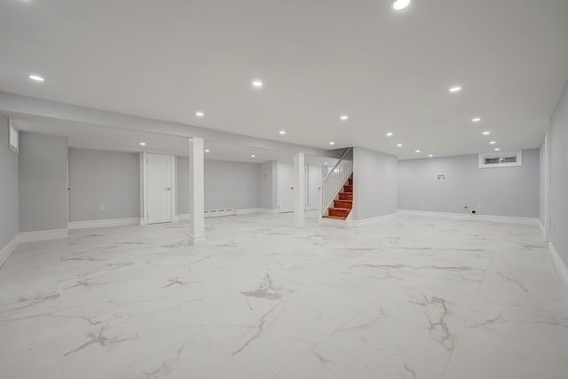 finished below grade area with recessed lighting, stairway, marble finish floor, baseboards, and baseboard heating