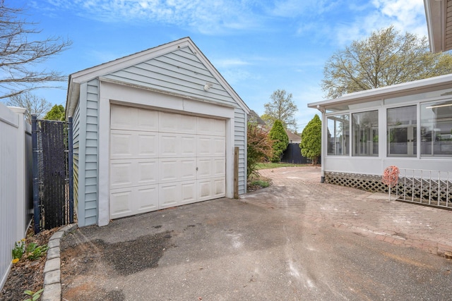 detached garage with fence and aphalt driveway