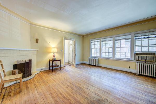 sitting room featuring light wood finished floors, radiator heating unit, a brick fireplace, and crown molding