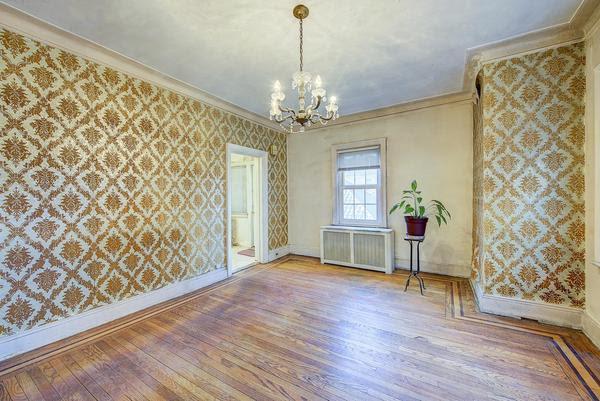 empty room featuring crown molding, radiator heating unit, wood finished floors, and wallpapered walls