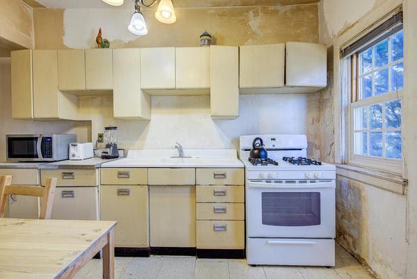 kitchen featuring light countertops, cream cabinets, stainless steel microwave, and white range with gas stovetop