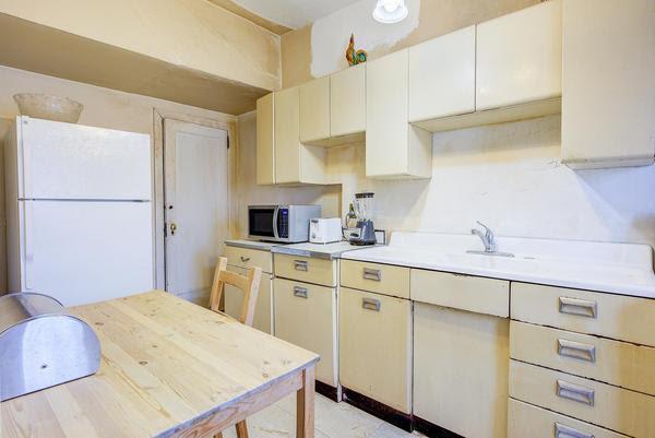 kitchen with freestanding refrigerator, light countertops, and stainless steel microwave