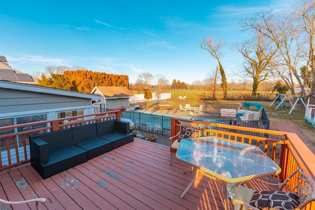 deck with outdoor dining space, an outdoor living space with a fire pit, and a playground