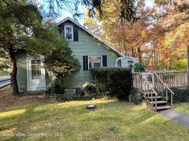 view of side of home featuring a deck and a lawn