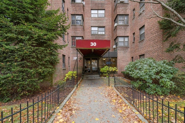 entrance to property with fence and brick siding