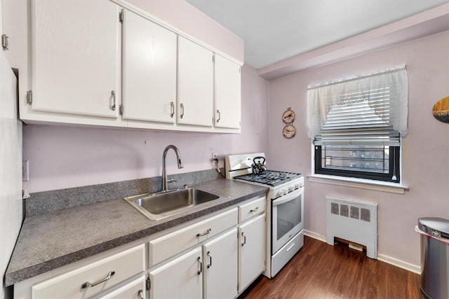 kitchen featuring a sink, white cabinetry, radiator, gas range gas stove, and dark countertops