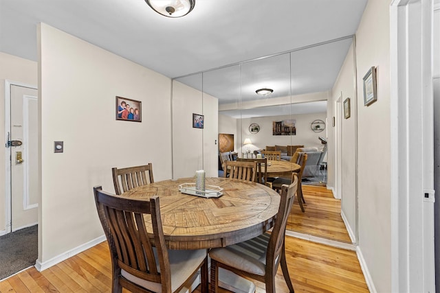 dining area with light wood-style flooring and baseboards