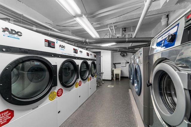 community laundry room featuring washing machine and dryer and a sink