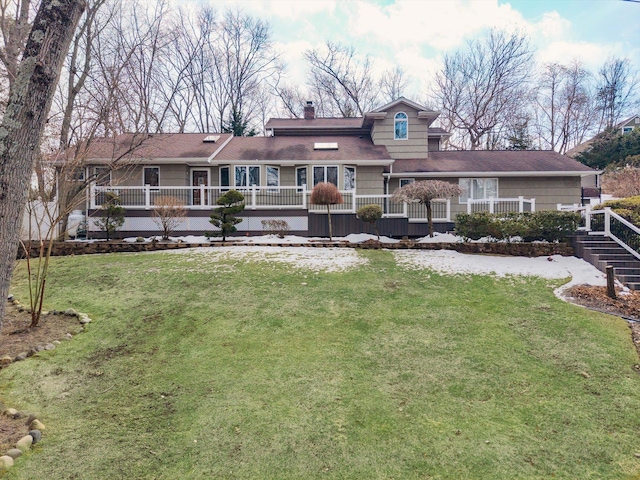 rear view of property with a chimney and a yard