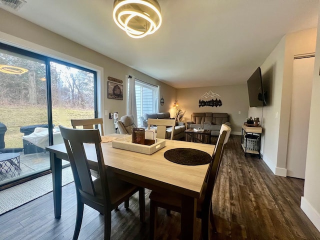 dining space featuring dark wood-style floors, visible vents, and baseboards