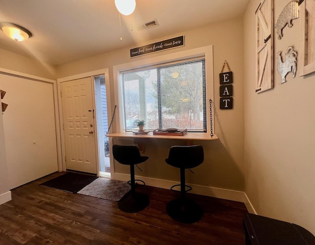 foyer entrance with baseboards, visible vents, and dark wood finished floors