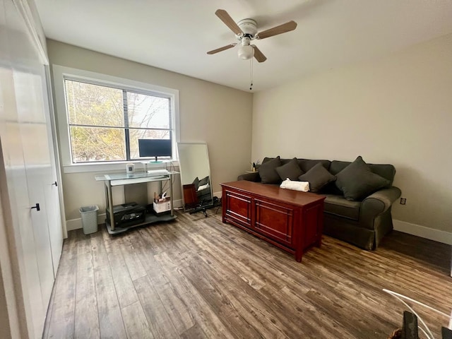 interior space featuring ceiling fan, baseboards, and wood finished floors