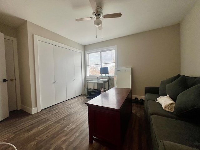 office space with dark wood-type flooring, a ceiling fan, and baseboards