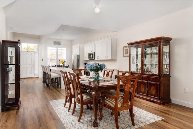 dining space featuring baseboards and wood finished floors