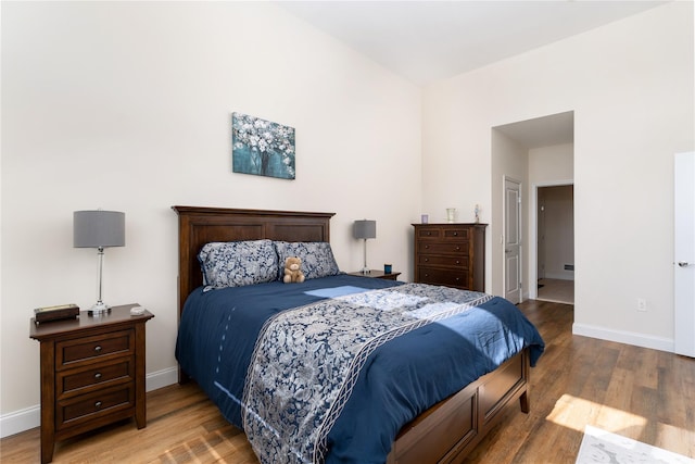 bedroom with baseboards and wood finished floors