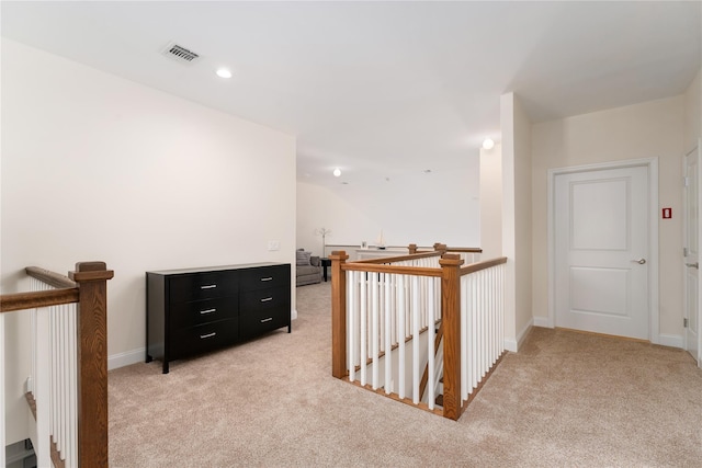 corridor featuring recessed lighting, light colored carpet, visible vents, and an upstairs landing