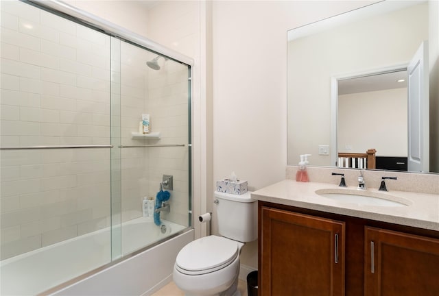 bathroom with toilet, combined bath / shower with glass door, and vanity