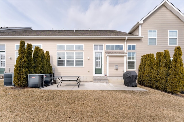 back of property with cooling unit, a patio area, a yard, and entry steps