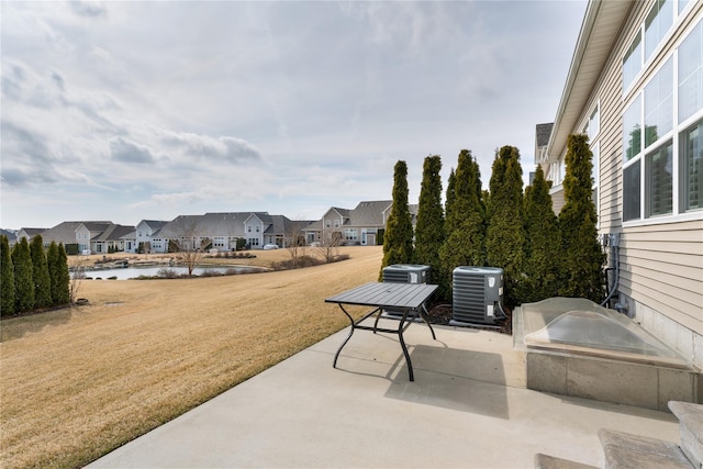 view of patio / terrace with a water view, a residential view, and central air condition unit