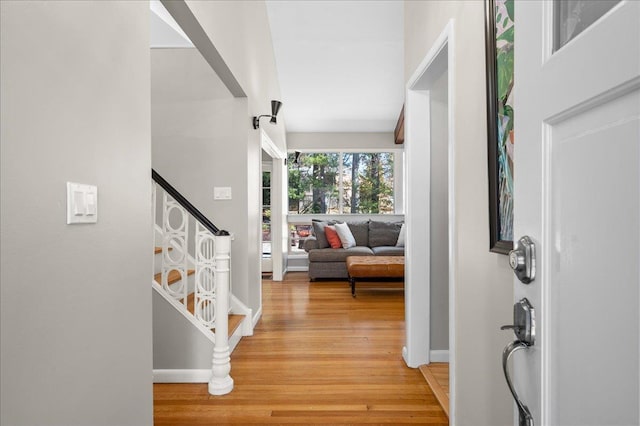 entryway featuring stairway, baseboards, and light wood-style floors