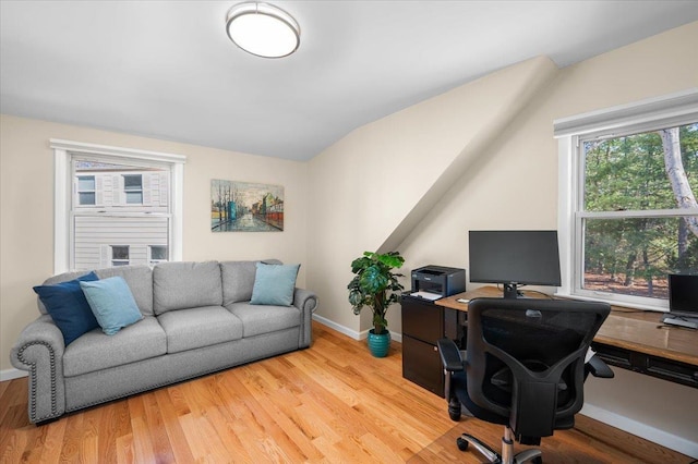 office area with vaulted ceiling, baseboards, and light wood finished floors