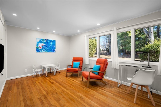 living area with recessed lighting, ornamental molding, baseboards, and wood-type flooring