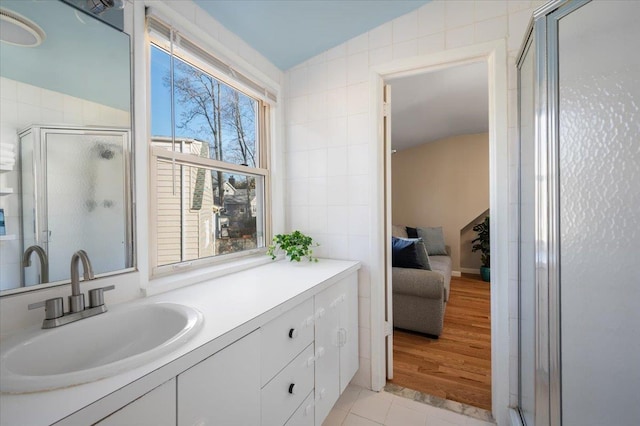 ensuite bathroom with ensuite bath, a stall shower, tile walls, and lofted ceiling