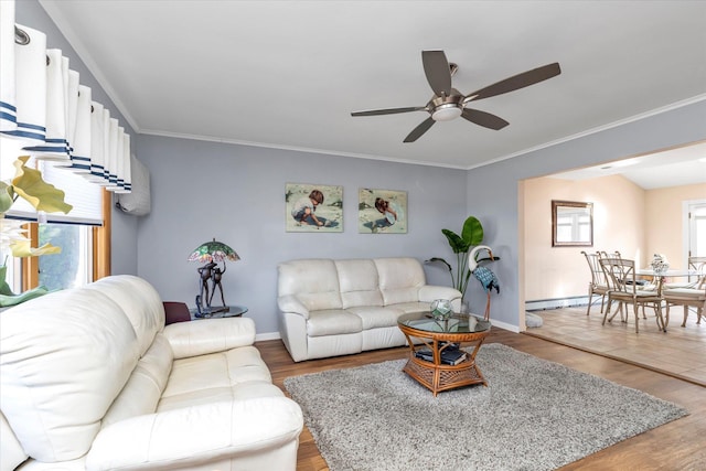 living area with a baseboard heating unit, light wood-type flooring, and ornamental molding