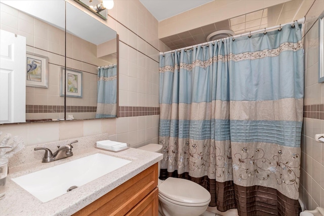 bathroom with toilet, a shower with shower curtain, tile walls, and vanity