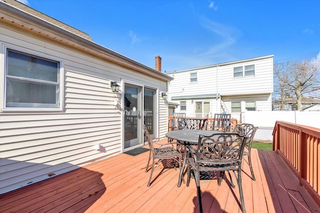 wooden terrace with outdoor dining space and fence