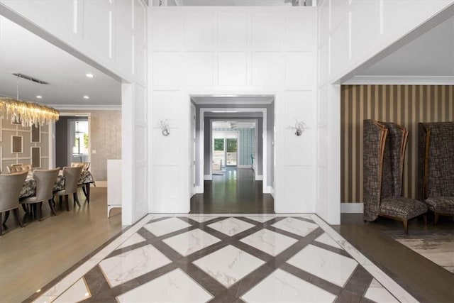 hallway featuring ornamental molding and a decorative wall