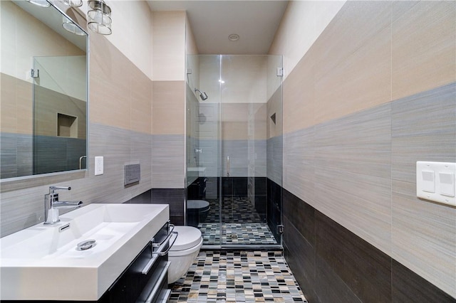 full bathroom featuring a shower stall, tile walls, toilet, and vanity