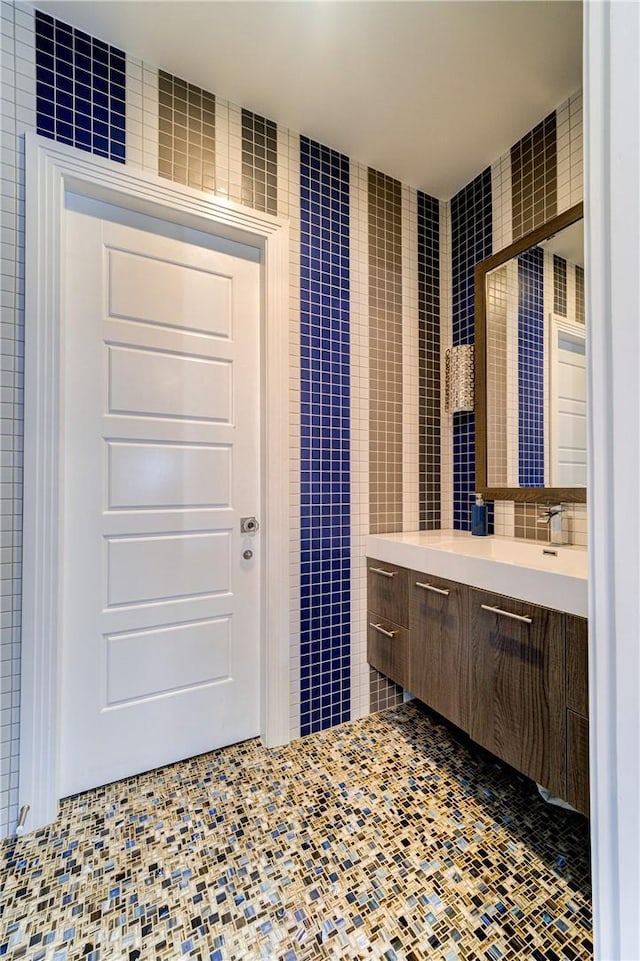 full bathroom with tile walls and vanity