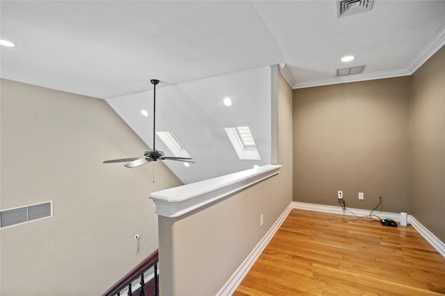 room details featuring a skylight, baseboards, visible vents, and wood finished floors