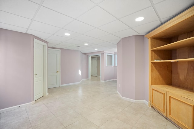 unfurnished room with recessed lighting, a drop ceiling, baseboards, and light tile patterned floors