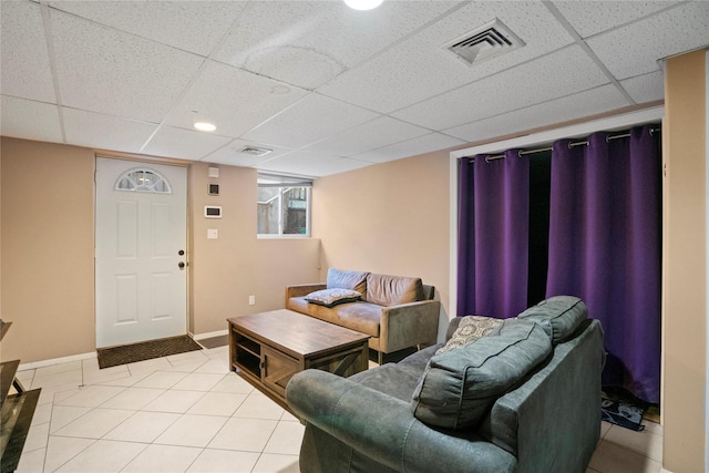 living room featuring a paneled ceiling, light tile patterned flooring, visible vents, and baseboards