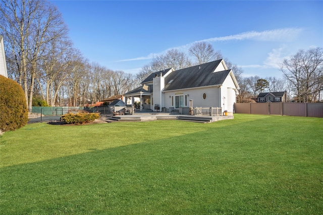 back of house featuring a fenced backyard, a chimney, a deck, and a yard