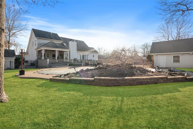 rear view of property with a yard, a patio, and fence