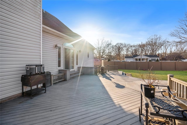 wooden terrace featuring a yard and fence