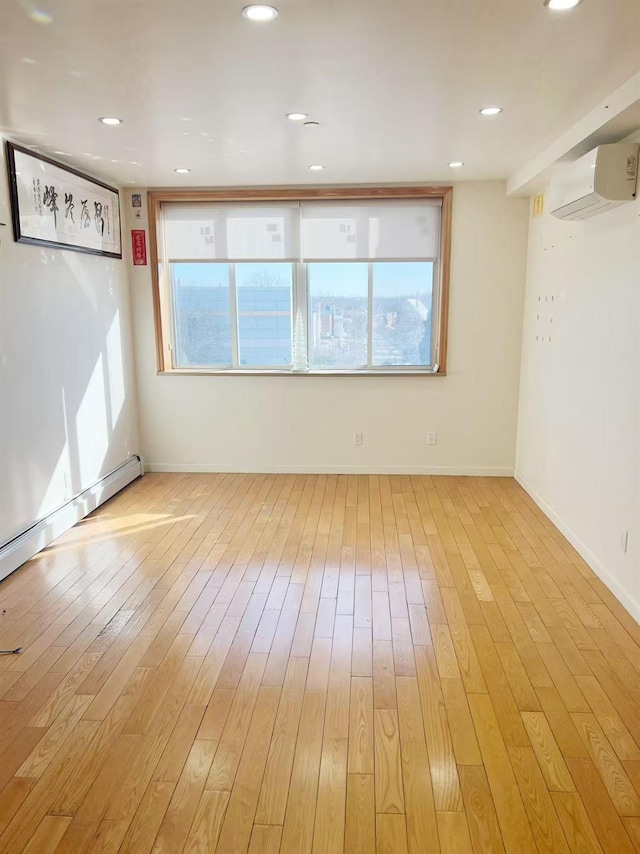 spare room featuring a wealth of natural light, light wood-style flooring, baseboards, and recessed lighting