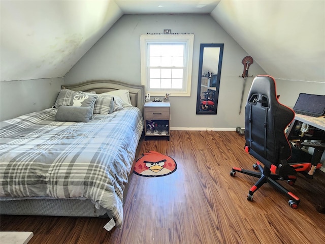 bedroom featuring baseboards, vaulted ceiling, and wood finished floors