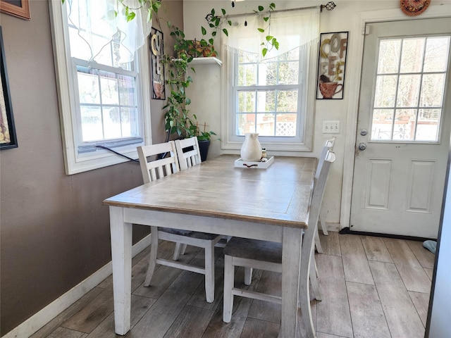 dining area featuring wood tiled floor and baseboards