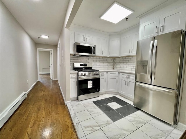 kitchen featuring a baseboard heating unit, white cabinetry, appliances with stainless steel finishes, and light countertops