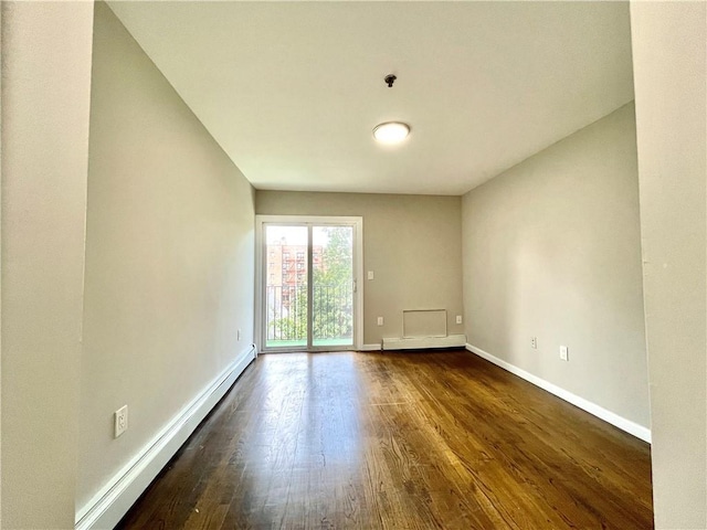 unfurnished room featuring a baseboard heating unit, baseboard heating, baseboards, and dark wood-style floors