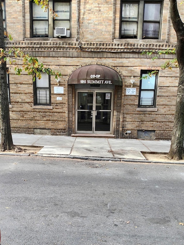 entrance to property with brick siding and cooling unit