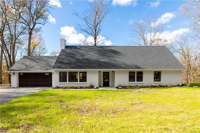 view of front of property with a shingled roof, a chimney, aphalt driveway, an attached garage, and a front lawn