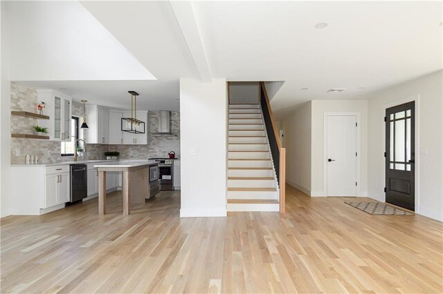 interior space with light wood-style floors, baseboards, stairs, and visible vents