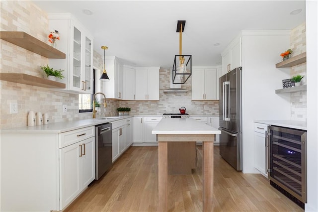 kitchen featuring open shelves, stainless steel appliances, white cabinets, a sink, and beverage cooler